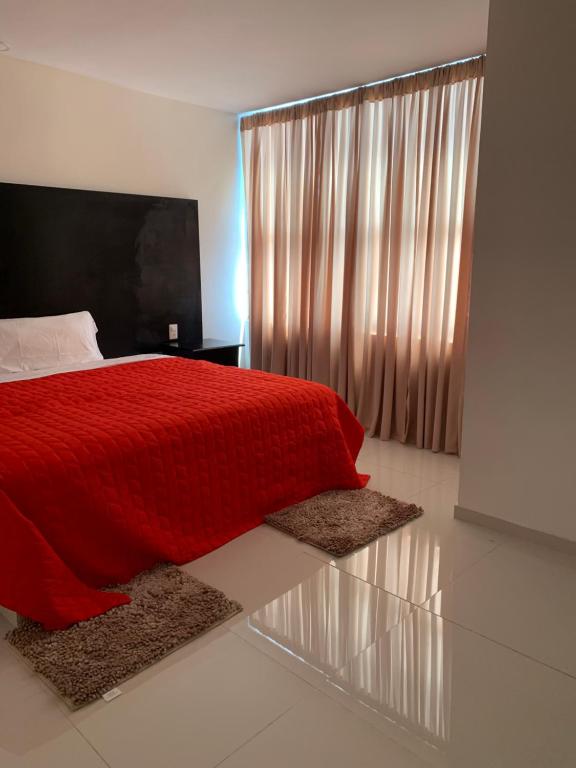 a bedroom with a red bed with two rugs at Tokyo Motel in San Bernabé Amaxac de Guerrero