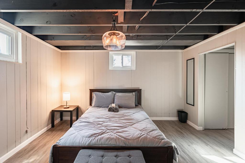 a bedroom with a large bed and a lamp at Centrally Located Basement Studio 