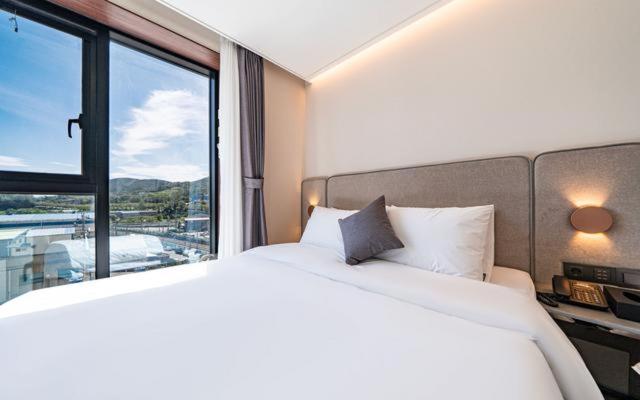 Postel nebo postele na pokoji v ubytování Hound Hotel Gijang Osiria