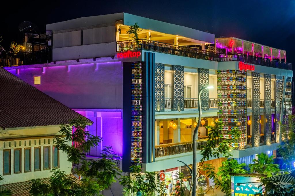 um edifício com luzes roxas à noite em DEJAVU 2.0 HOTEL BAJO KOMODO em Labuan Bajo