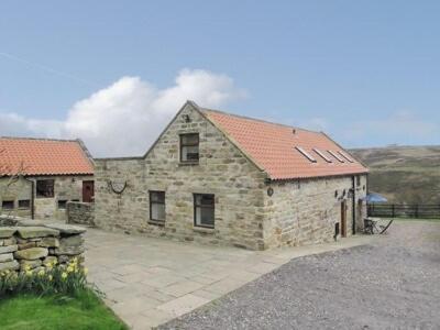 a large stone building with a red roof at The Old Barn in Commondale