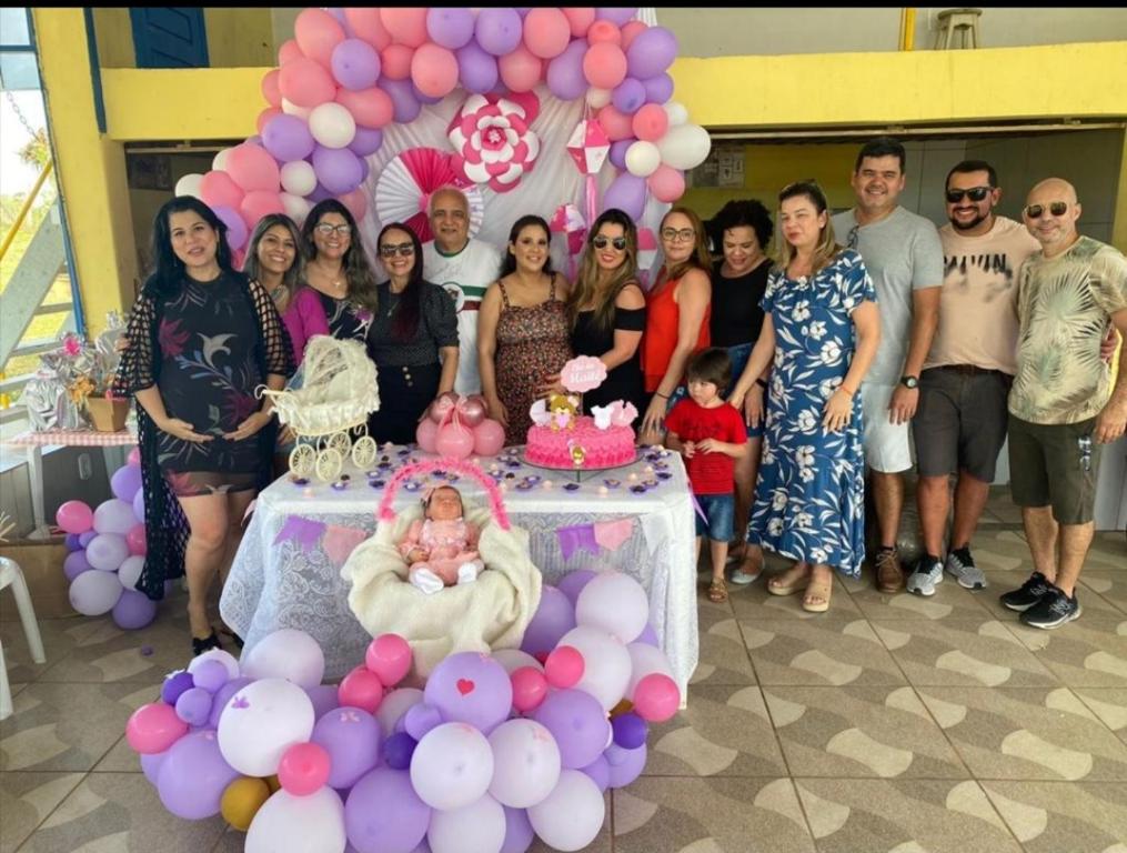 un grupo de personas de pie alrededor de una mesa con un pastel en ESPACO LEÃO EVENTOS, Chácara para eventos, lazer ou descanso, en Rio Branco