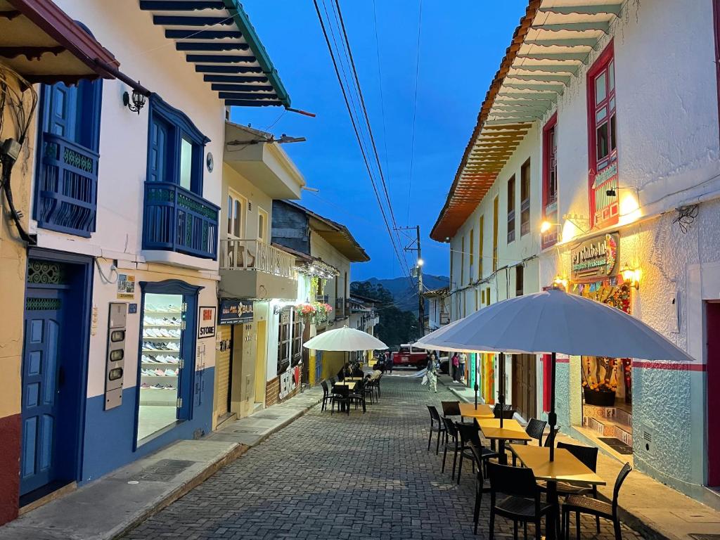 an empty street with tables and chairs and an umbrella at JericóHouse apto 202 in Jericó