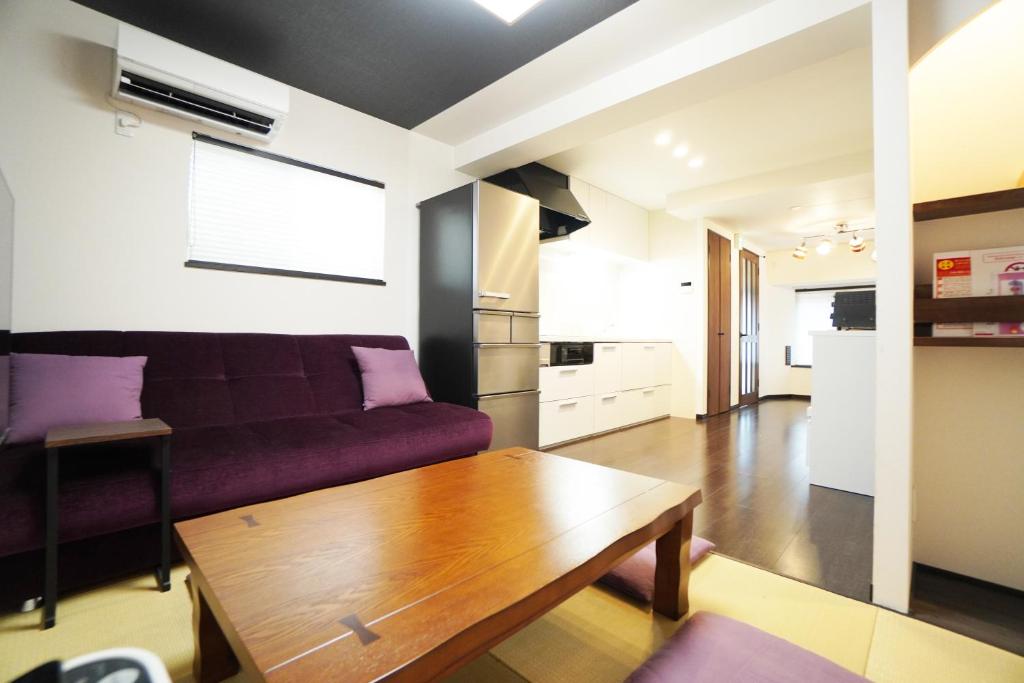 a living room with a purple couch and a wooden table at ANGO KYOTO Ⅰ in Kyoto