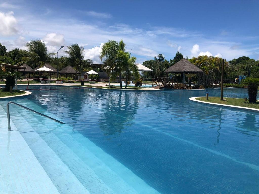 a large pool with blue water in a resort at Apê Laranja Iloa Barra de São Miguel in Barra de São Miguel