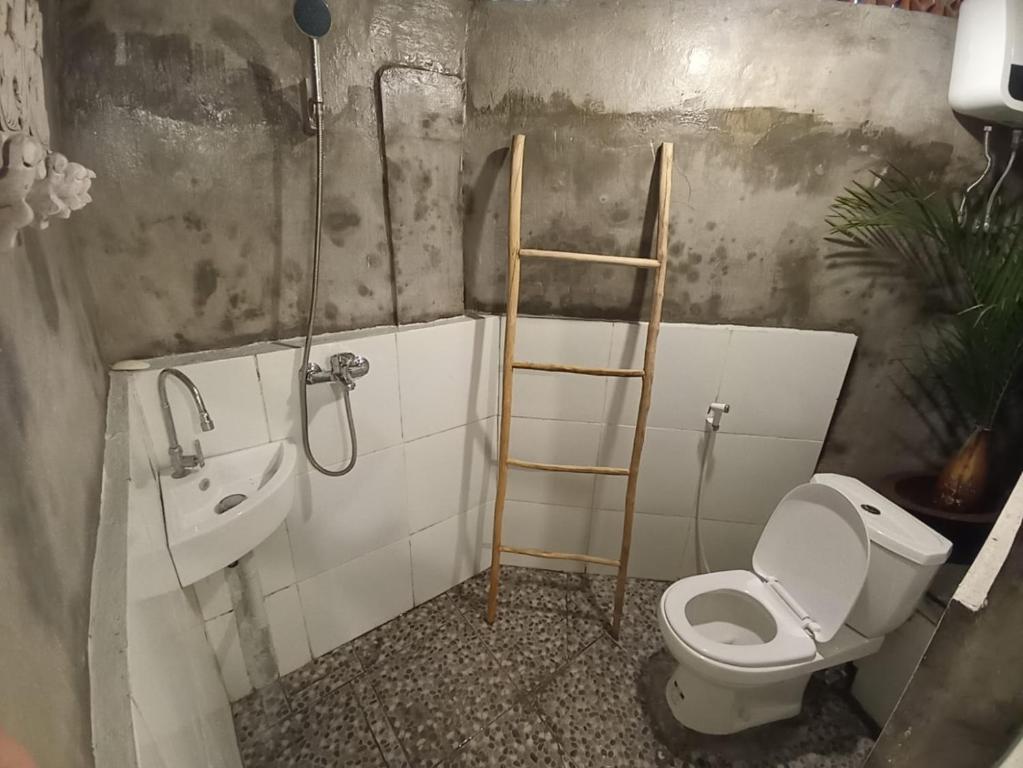 uma casa de banho com uma escada ao lado de um WC e um lavatório em Classic Local House Grenceng em Denpasar