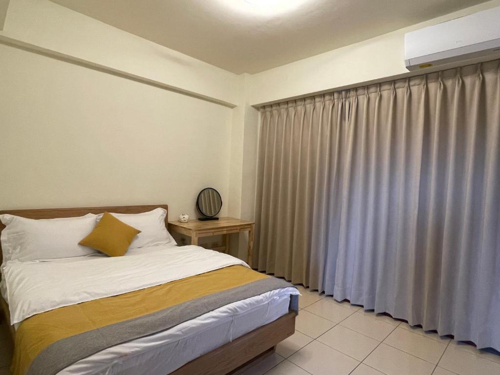 a bedroom with a bed and a window with curtains at 埔里北梅民宿BEI MEI Homestay可包棟 in Puli