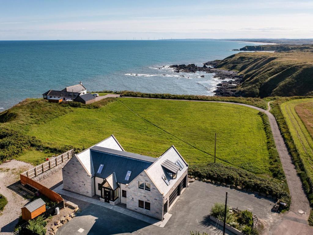 an aerial view of a house with the ocean at Murlin in Collieston