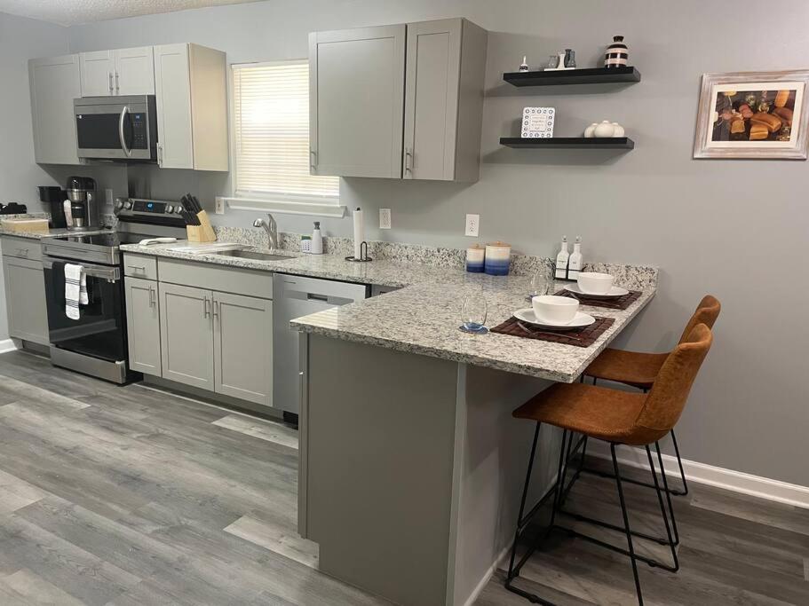 a kitchen with white cabinets and a counter with a stool at Downtown Home in Chattanooga in Chattanooga