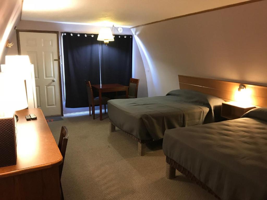 a hotel room with two beds and a table at The little chalet motel in Brandon