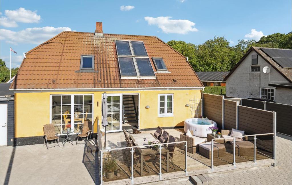una casa amarilla con una terraza frente a ella en Cozy Home In Egernsund With Wifi en Egernsund