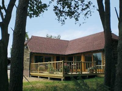 a house with a large deck with a porch at The Old Packhouse in Steyning