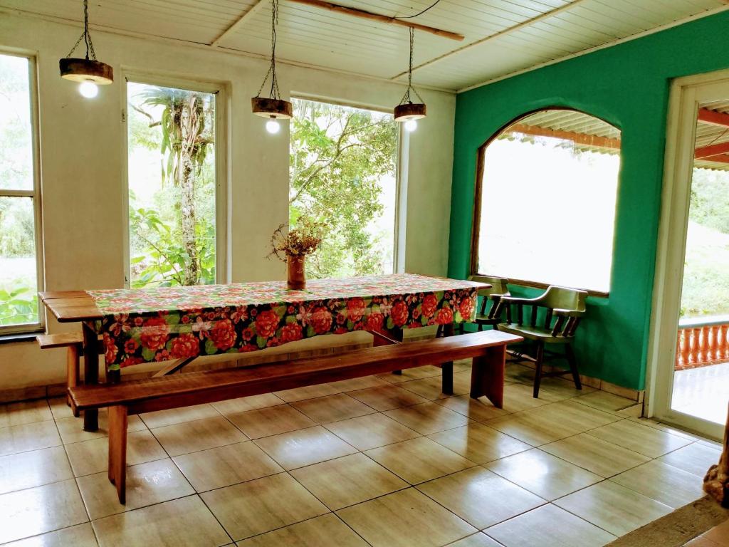 a table in a room with a bench in a room at Hostel Rural Família Mulareks in Natividade da Serra