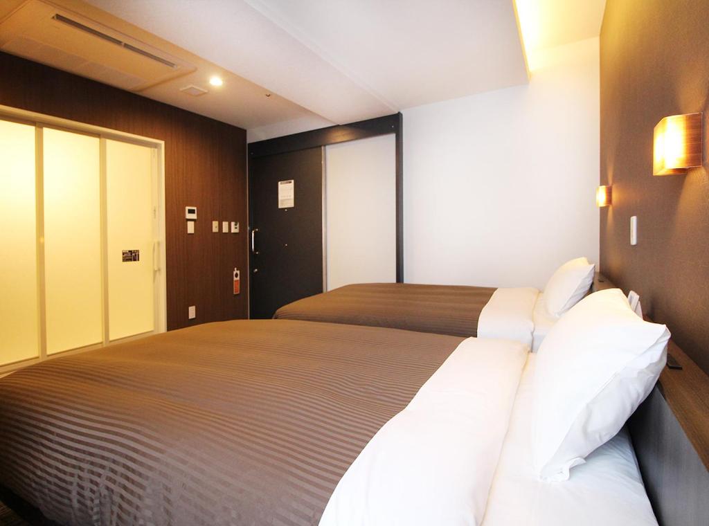 Postel nebo postele na pokoji v ubytování Hotel Trend Takatsuki