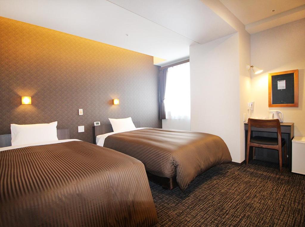 Postel nebo postele na pokoji v ubytování Hotel Trend Takatsuki