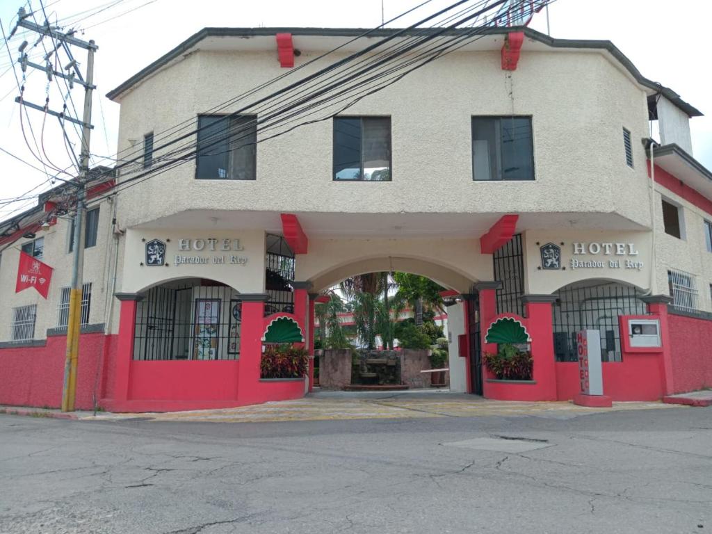 un edificio rojo y blanco con una entrada arqueada en Hotel Parador del Rey, en Temixco