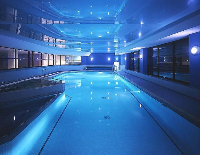 a large swimming pool in a building with blue lights at Burrow Meadows in Casterton