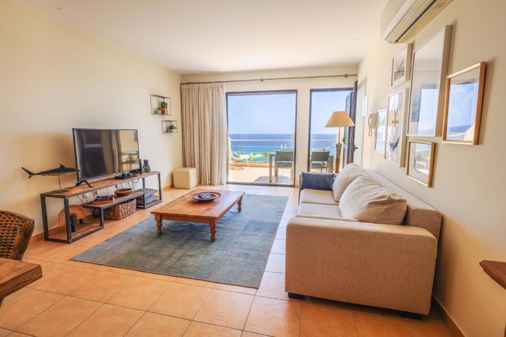 a living room with a couch and a table and a television at Pedra do Jota in Porto Santo