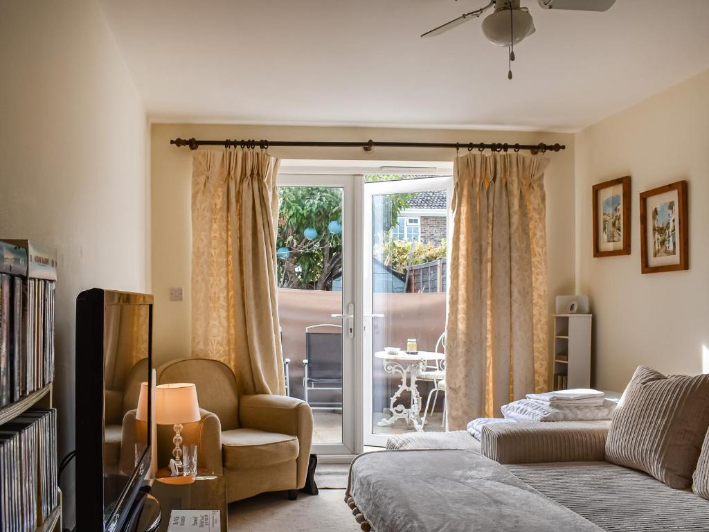 a living room with a bed and a sliding glass door at Kingsway Apartment in Langstone