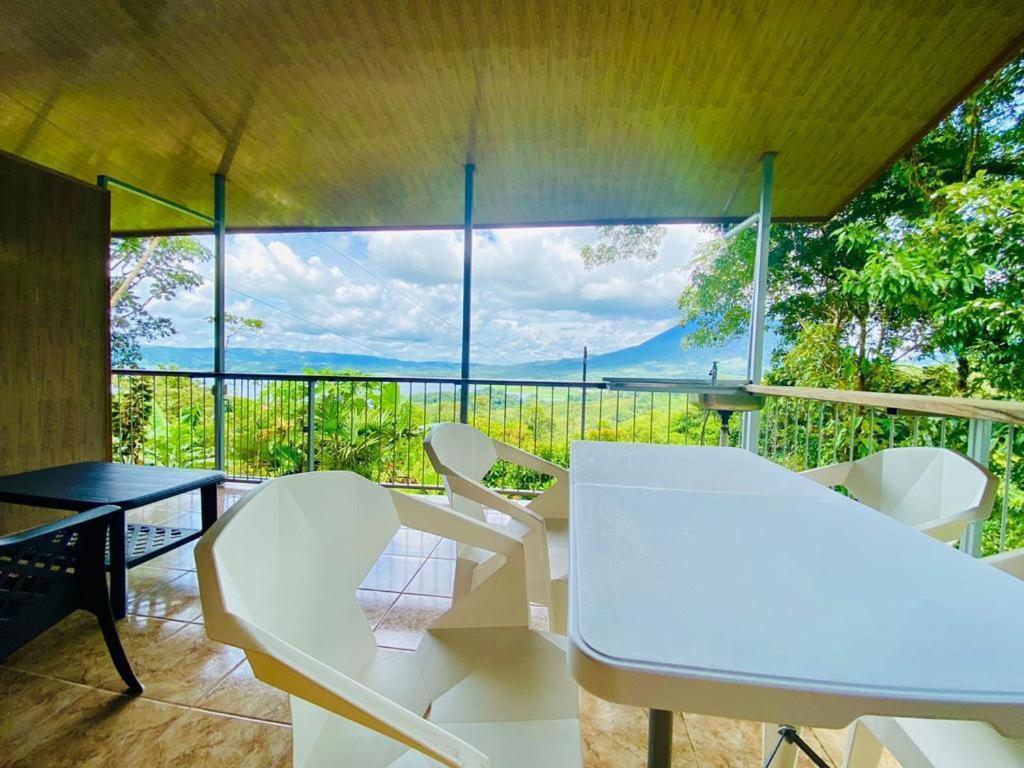 a room with a table and chairs and a large window at Arenal Jungla Lodge in San Ramón