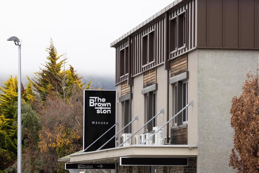 un edificio con un cartel en el costado en The Brownston Hostel en Wanaka