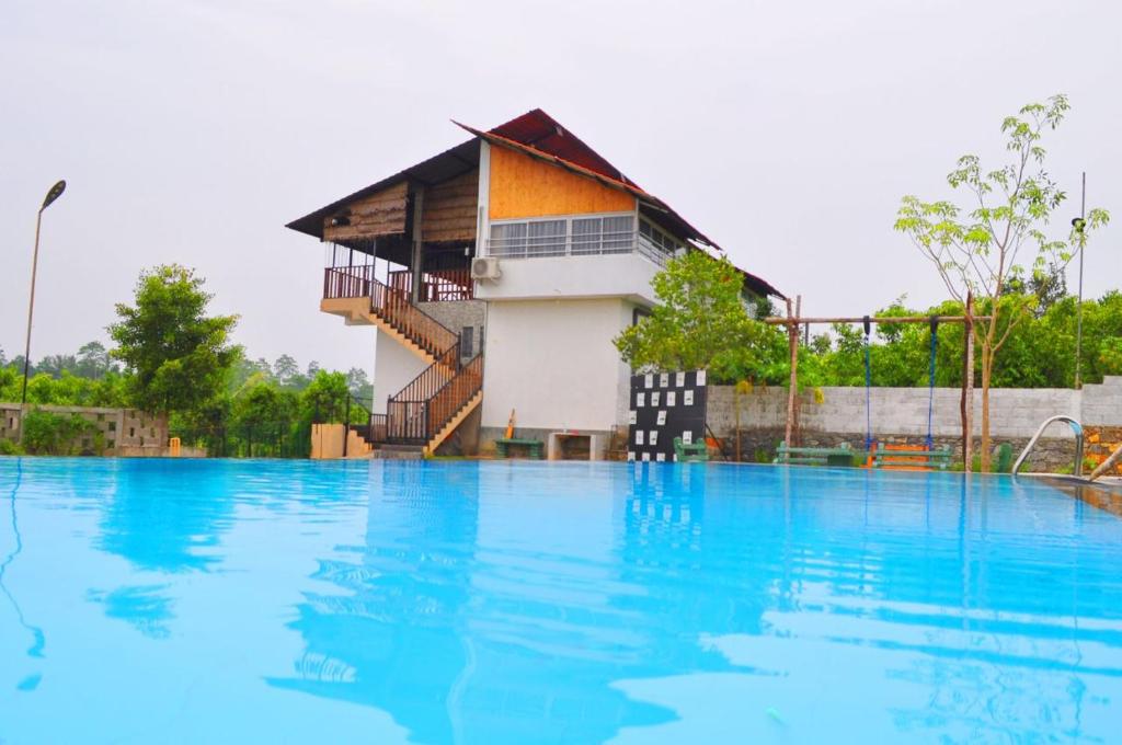 una grande piscina con un edificio sullo sfondo di Villa Cinnamon Nature a Beruwala