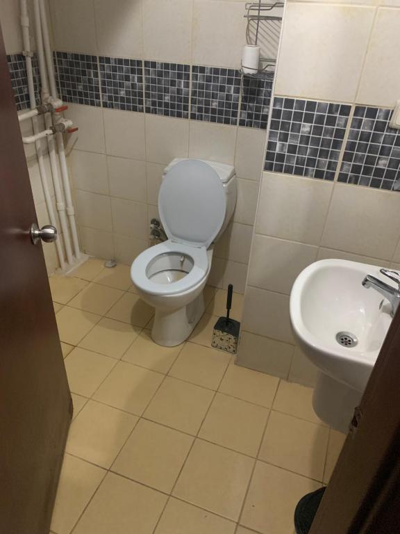 a bathroom with a toilet and a sink at Altunlar erkek ögrenci yurdu in Altındağ