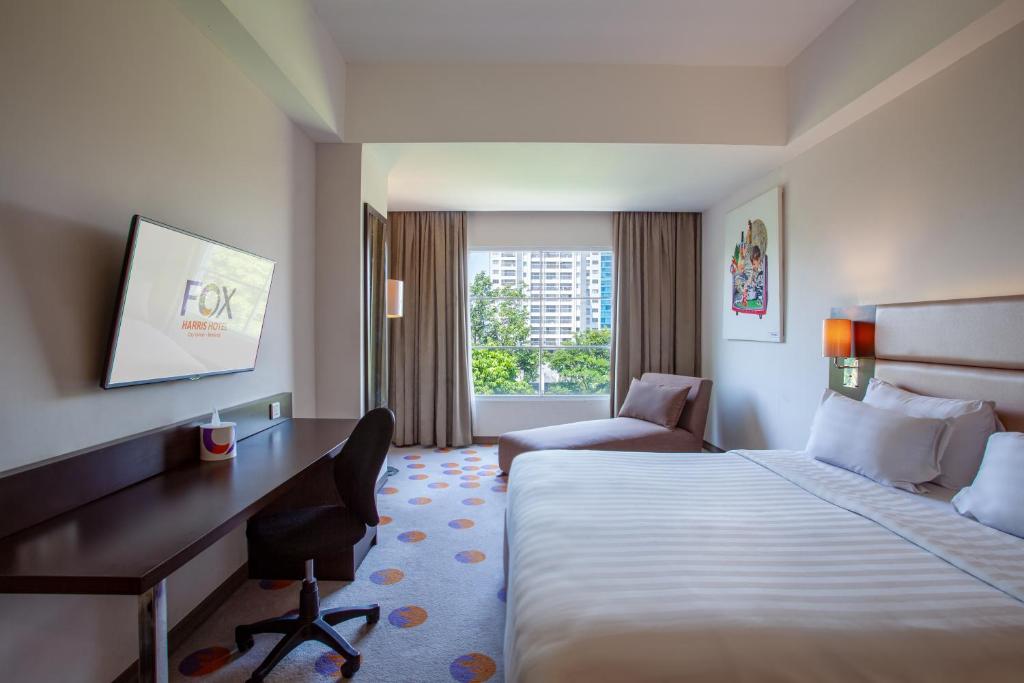 a hotel room with a bed and a desk at FOX HARRIS City Center Bandung in Bandung