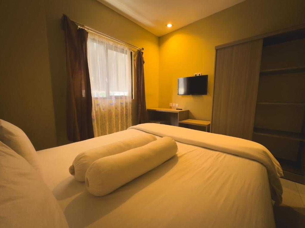 Una toalla blanca puesta en una cama en una habitación en Mess MT Haryono en Sampit