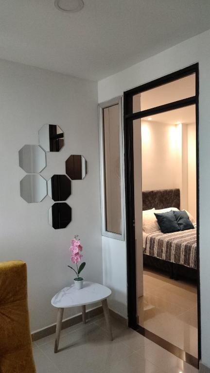 um quarto com um espelho, uma cama e uma mesa em 202-Cómodo y moderno apartamento de 2 habitaciones en la mejor zona céntrica de Ibagué em Ibagué