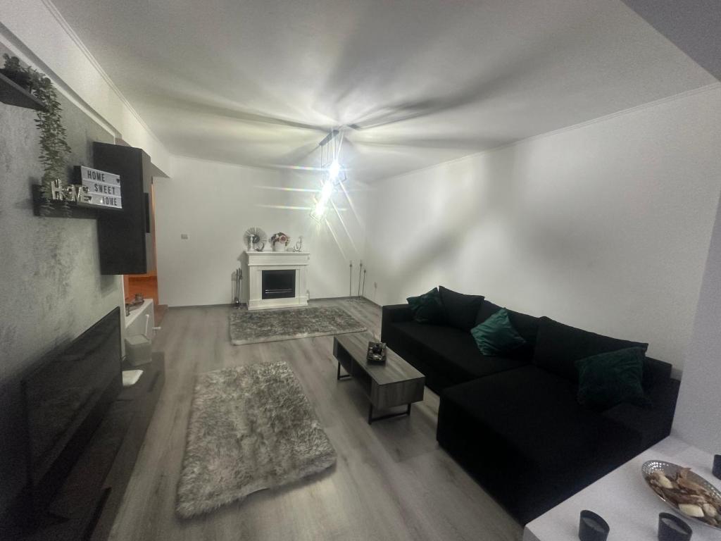 uma sala de estar com um sofá preto e uma lareira em Apartament Maria em Baile Govora