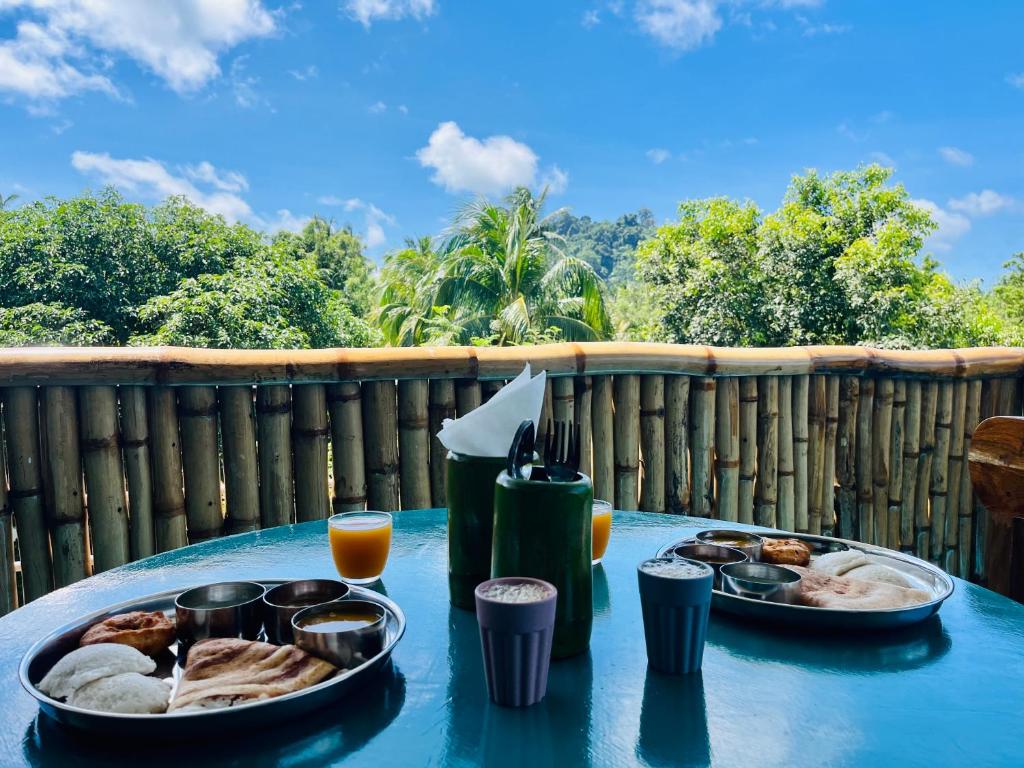a table with two plates of food on it at Bhūma in Havelock Island