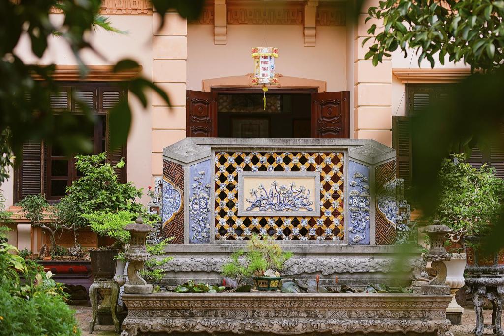 una panca di pietra di fronte a un edificio di HueNam Residence a Hue