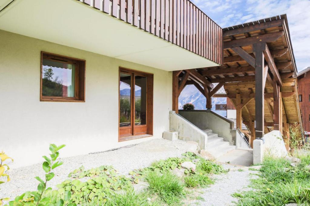 a home with a wooden porch and stairs to a house at Résidence Les Gentianes - maeva Home - Appartement 3 Pièces 6 Personnes - C 38 in Puy-Saint-Vincent