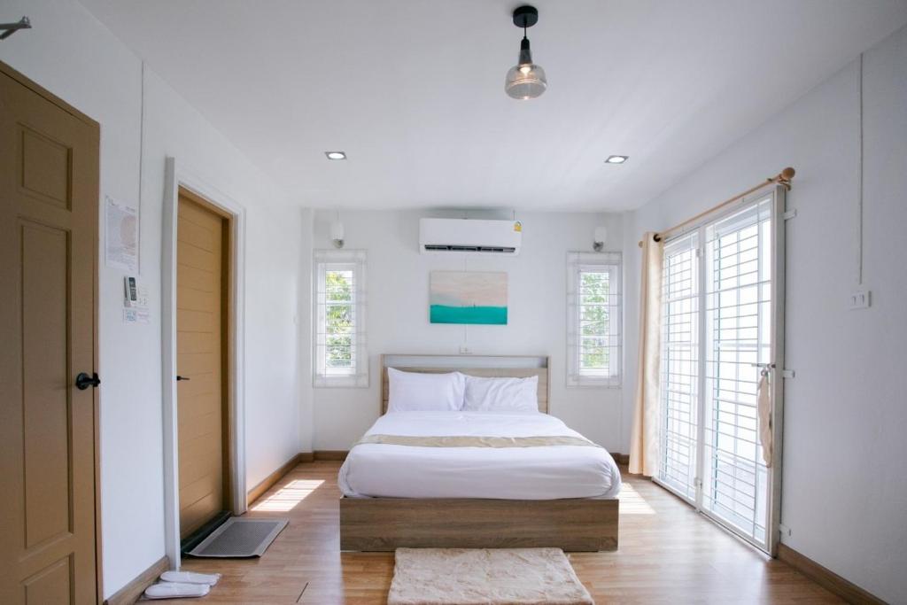 a bedroom with a white bed and a large window at DeliZia de Budget พักได้ 2 ท่าน in Satun