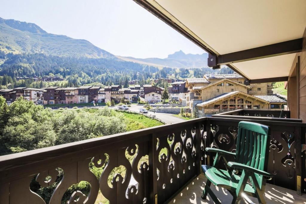 a green chair sitting on a balcony with a view at Quartier La Forêt - maeva Home - Appartement 2 Pièces 6 Personnes - Sélect 74 in Valmorel