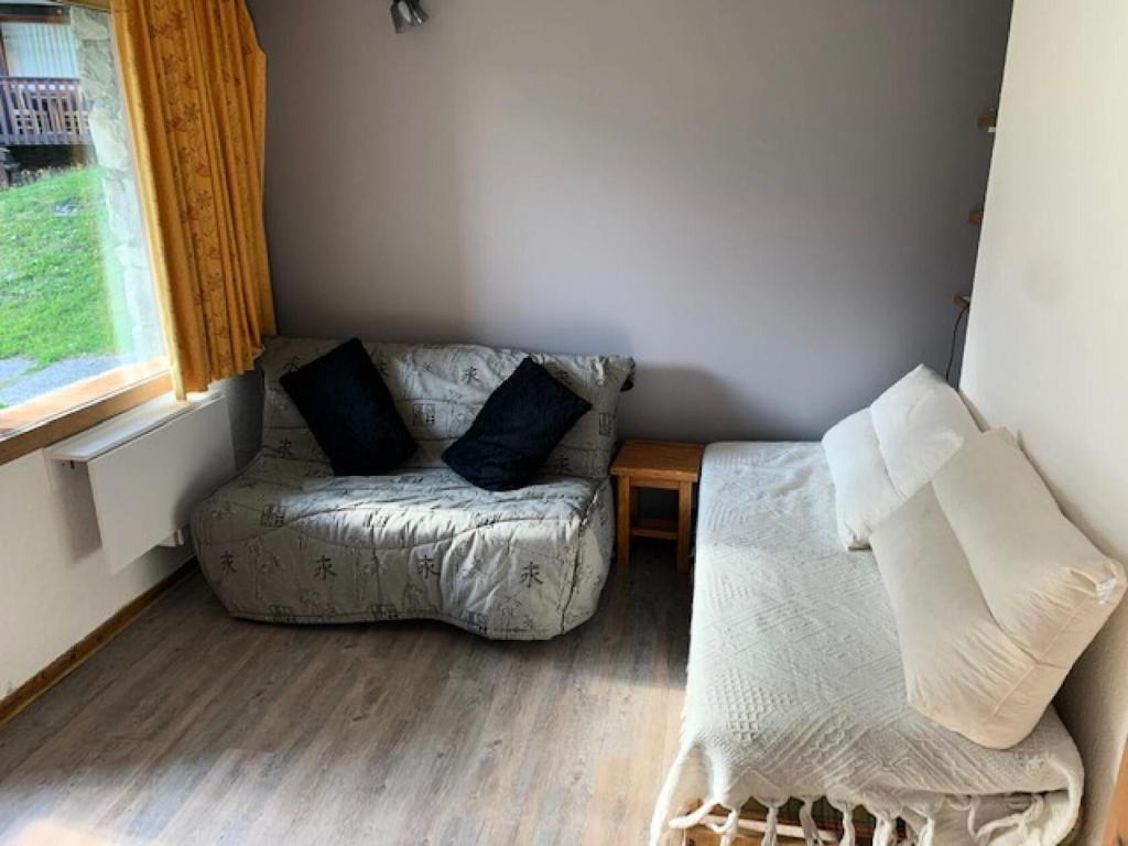 un salon avec un canapé et une fenêtre dans l'établissement Quartier Crève Cœur - maeva Home - Studio 5 personnes Sélection MAE-2906, à Valmorel