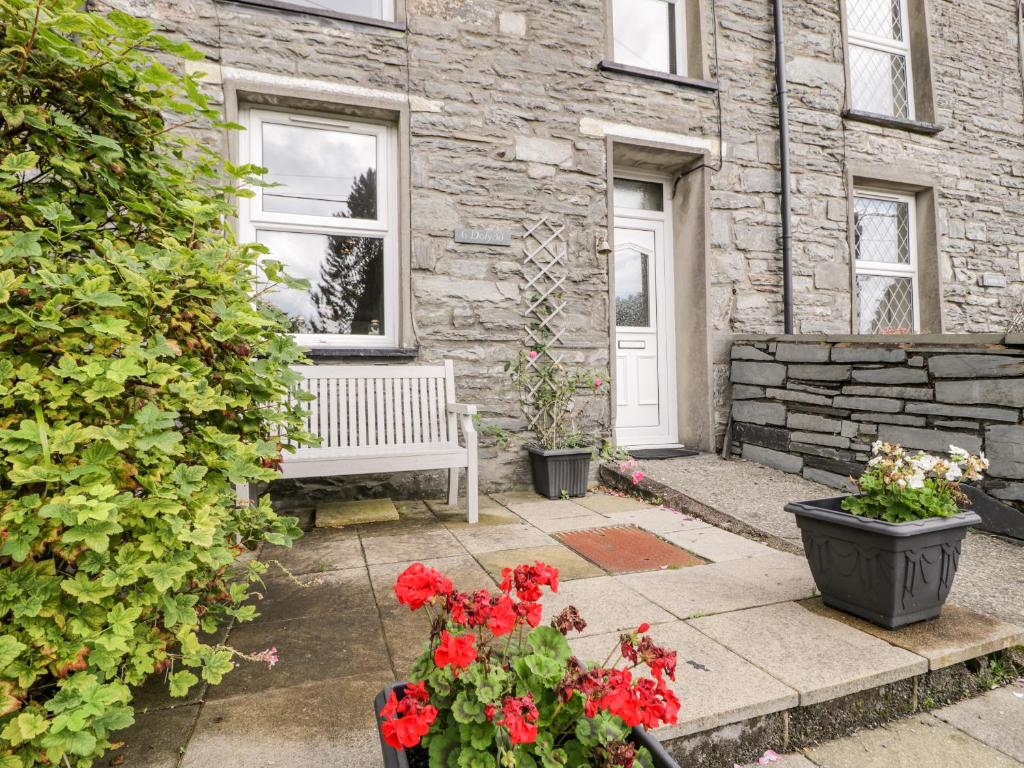 a patio with a bench and flowers in front of a building at Ty Gwynn in Tanygrisiau