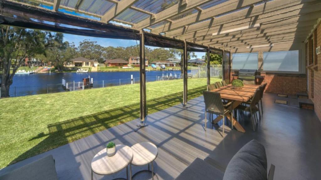 a deck with a table and a view of the water at Love the Let! in Sussex inlet