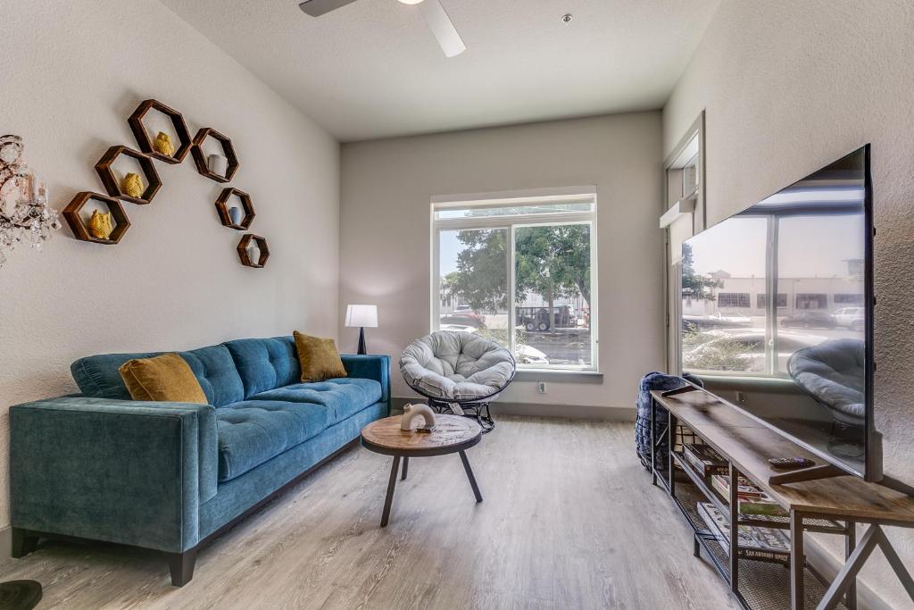 uma sala de estar com um sofá azul e uma mesa em Lush Downtown Condo on RiverWalk #1100 em San Antonio