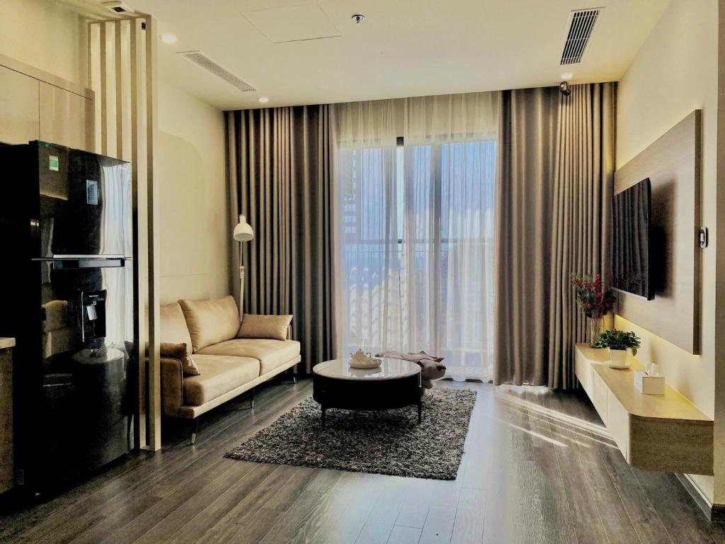 een woonkamer met een bank en een salontafel bij Shin's Conner- 1 bedroom apartment 50m2 at Vinhomes Ocean Park in Hanoi