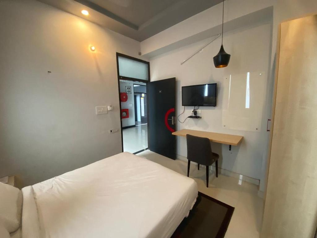 ein Hotelzimmer mit einem Bett und einem Schreibtisch. in der Unterkunft Jaipur Grand By StayApart in Jaipur