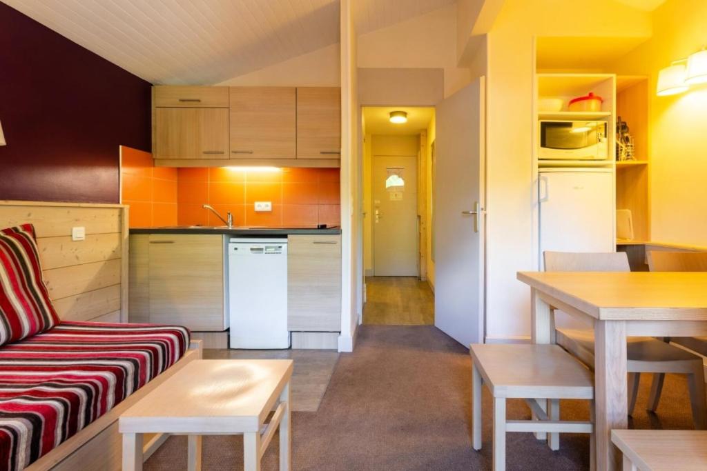 a living room and kitchen with a couch and a table at Résidence Plagne Lauze - maeva Home - Appartement 2 pièces 5 personnes - Confort MAE-9202 in Mâcot La Plagne