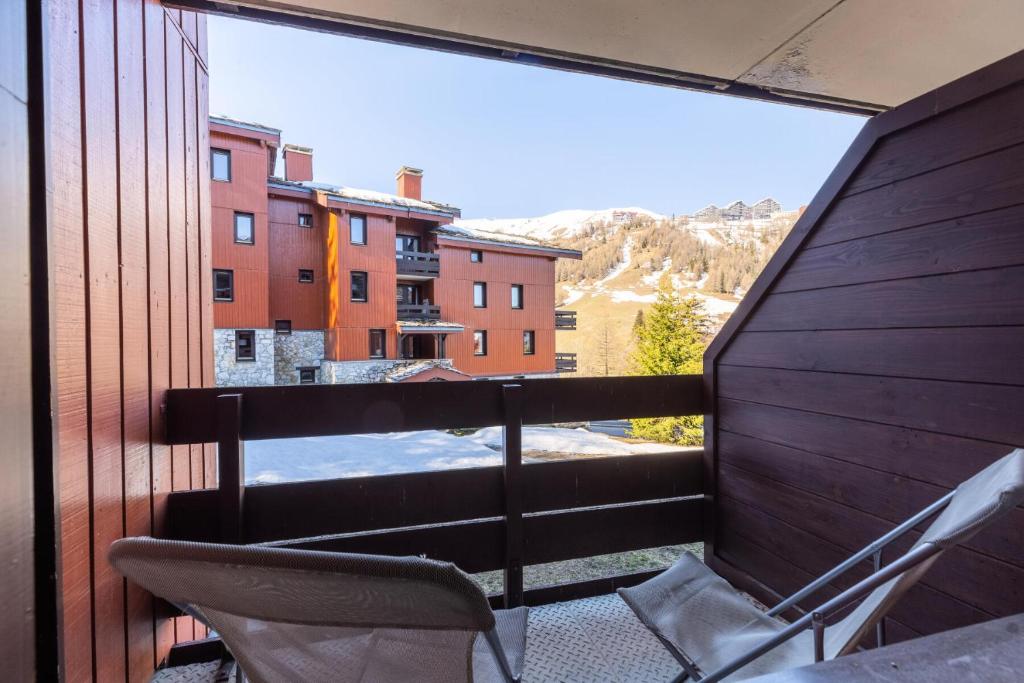 d'un balcon avec des chaises et une vue sur un bâtiment. dans l'établissement Résidence Plagne Lauze - maeva Home - Studio 4 personnes - Sélection MAE-1114, à Mâcot La Plagne