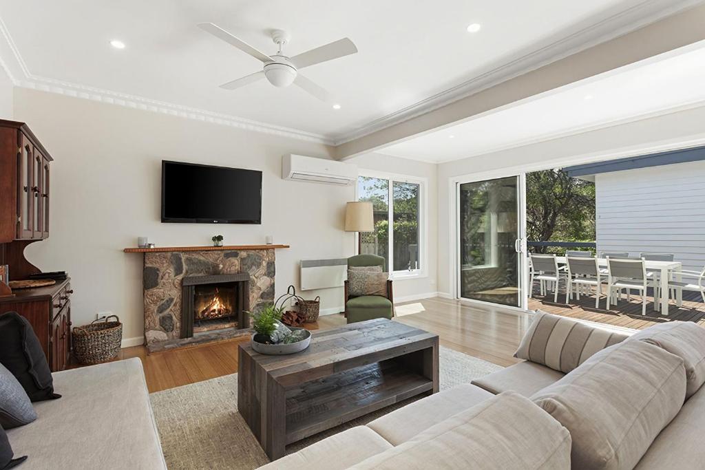 a living room with a couch and a fireplace at Curragundi in Point Lonsdale