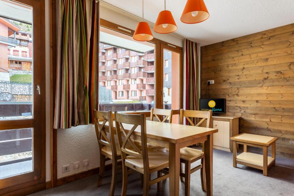 une salle à manger avec une table et des chaises et une fenêtre dans l'établissement Résidence Les Chalets des Arolles - maeva Home - Studio 4 Personnes - Budget MAE-5804, à La Plagne Tarentaise
