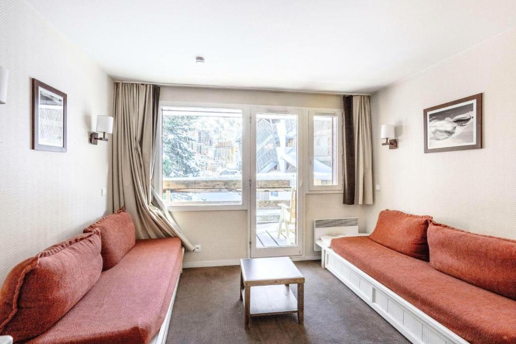 - un salon avec deux canapés rouges et une fenêtre dans l'établissement Résidence Quartier Falaise - maeva Home - Appartement 2 Pièces 6 Personnes - Sélection MAE-0524, à Avoriaz