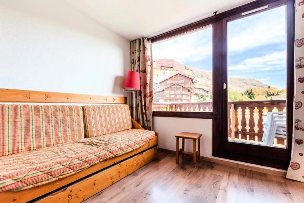 un salon avec un canapé et une grande fenêtre dans l'établissement Résidence Les Mélèzes - maeva Home - 2 Pièces 6 Personnes - Confort MAE-2144, à Huez