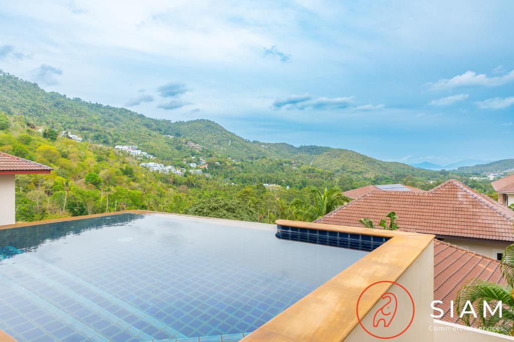 Chaweng Hill Apartment 2Br & Private Pool في كوه ساموي: مسبح في فيلا فيها جبال في الخلف