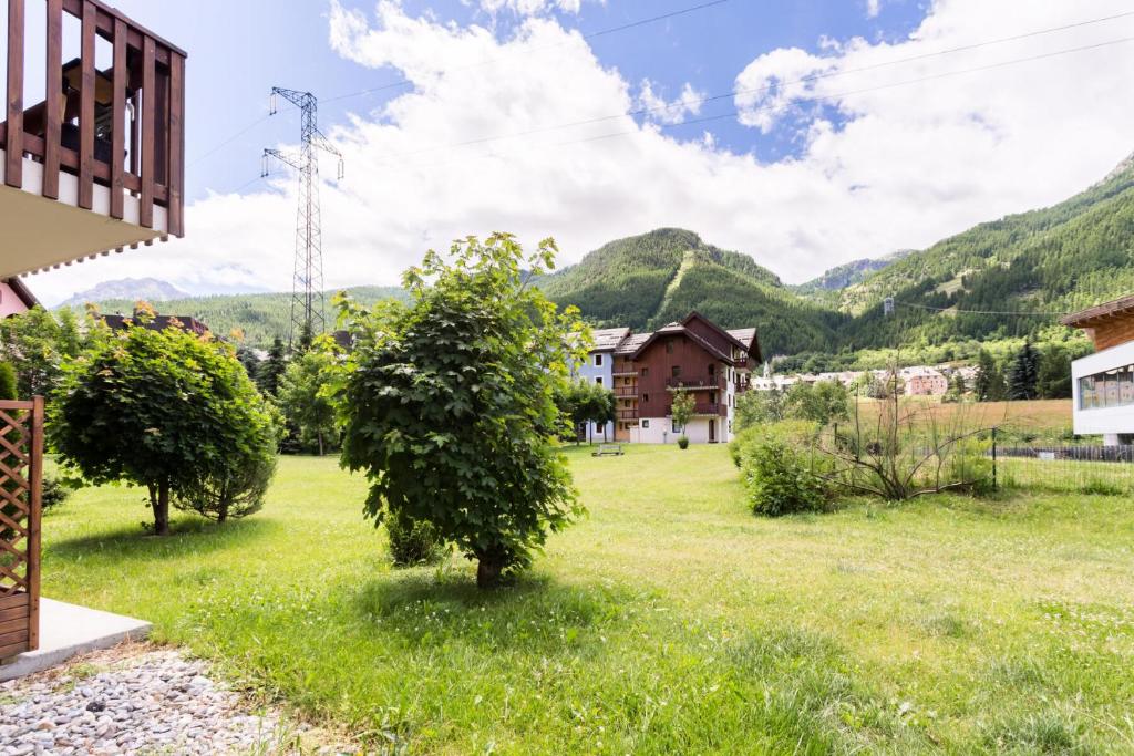 une maison avec une cour avec des montagnes en arrière-plan dans l'établissement Résidence L'Alpaga - maeva Home - Appartement 2 Pièces 5 Personnes - Budget MAE-9994, à La Salle Les Alpes